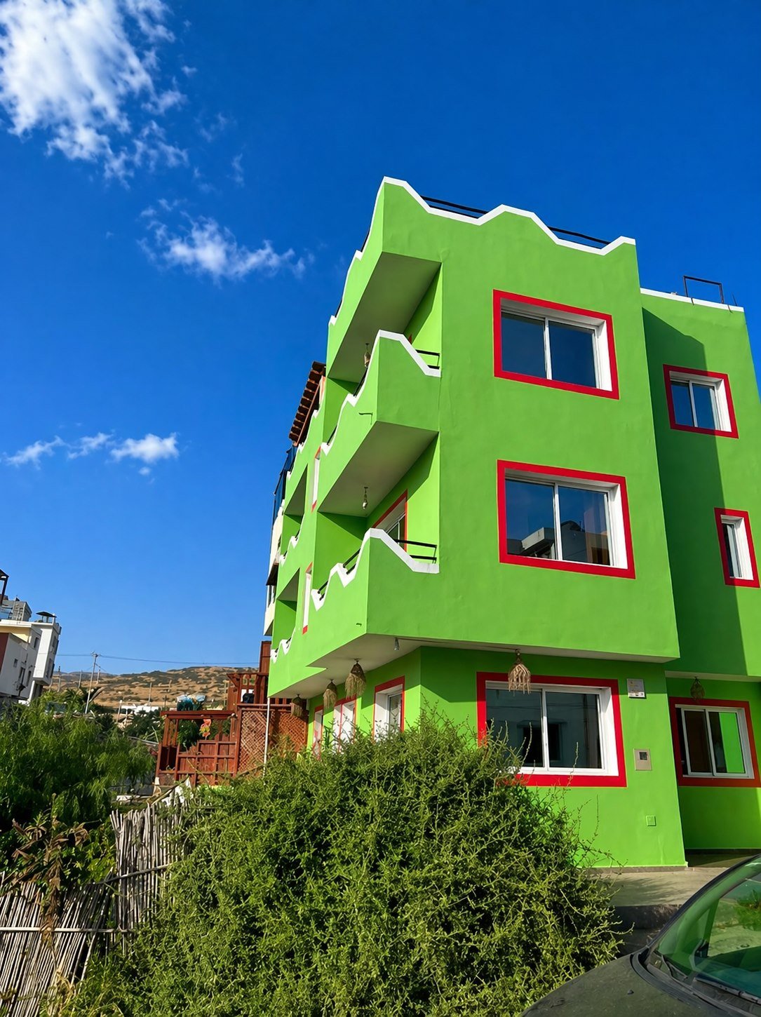 Dar Mouja green house facade in Imsouane under a bright blue sky