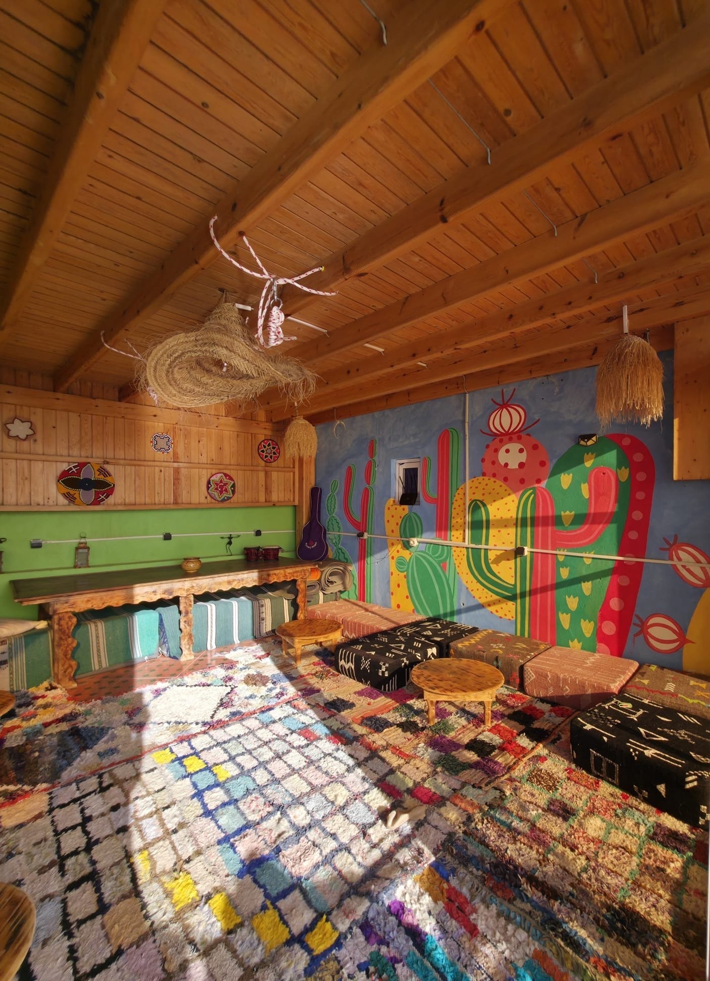Dar Mouja colourful Moroccan lounge with Berber rugs and wooden ceiling