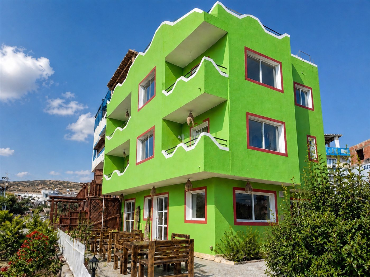 Dar Mouja green house exterior in Imsouane with balconies and blue sky